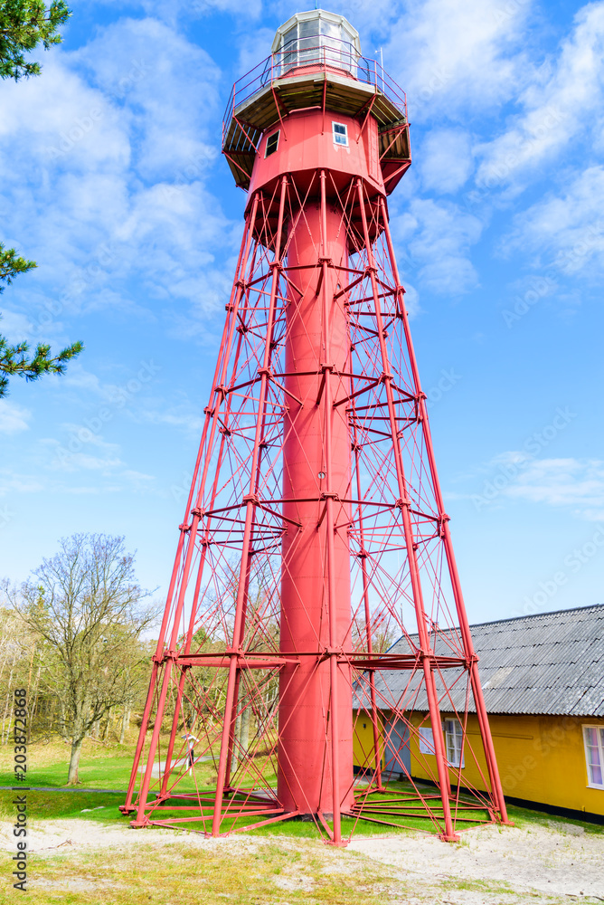 Sandhammaren, Sweden - Red metal lighthouse with outer framework and adjacent building.