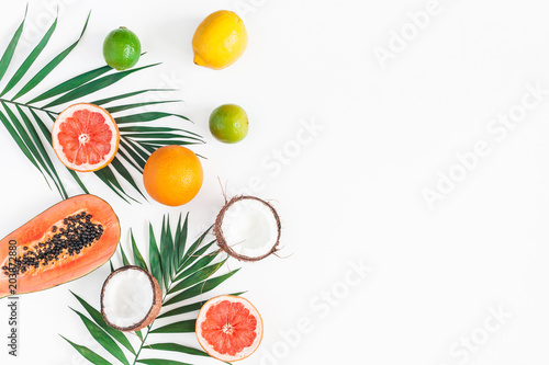 Summer tropical composition. Green palm leaves and tropical fruits on white background. Summer concept. Flat lay  top view  copy space