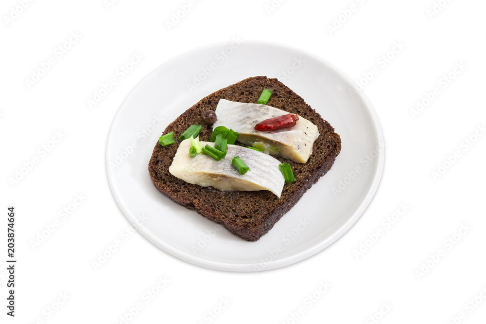 Open sandwich with slices of pickled herring on brown bread