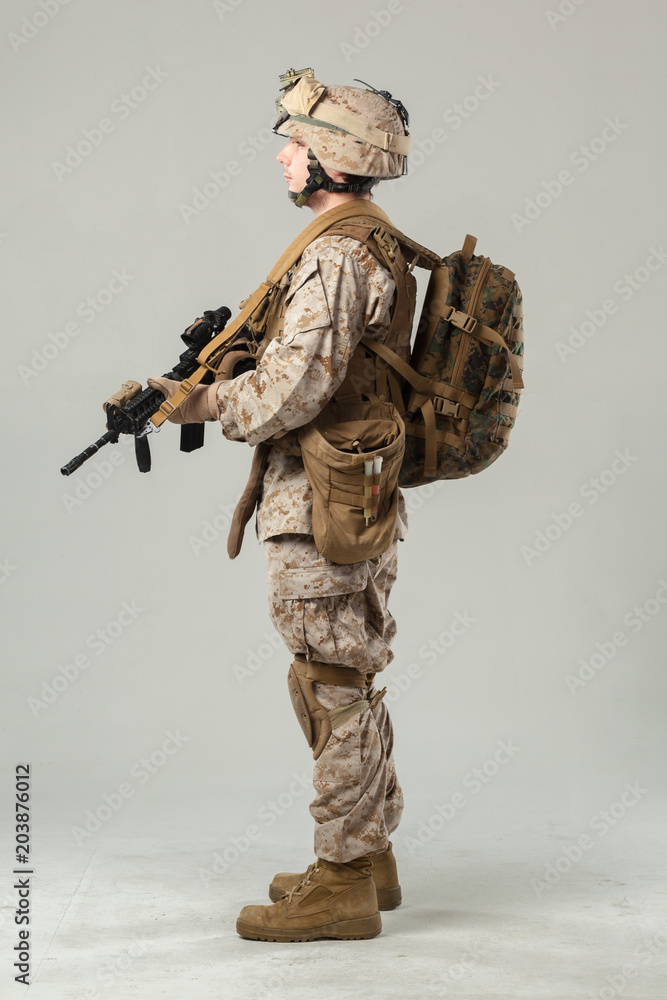 Soldier in camouflage holding rifle Soldier in camouflage holding rifle