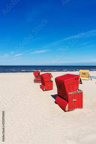 Fototapeta Naklejka Na Ścianę i Meble -  Red beach chairs on a sunny day at the Baltic Sea