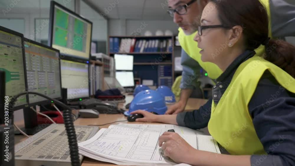 Technicians working in industrial plant control room