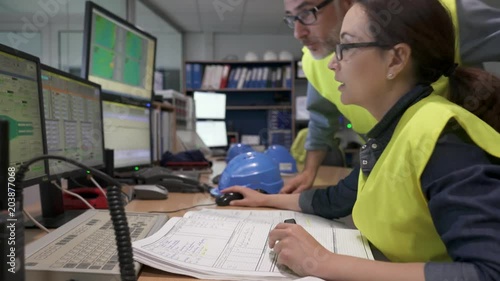 Technicians working in industrial plant control room