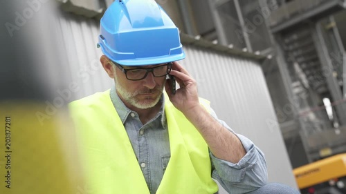 Industrial engineer in recycling plant using phone photo