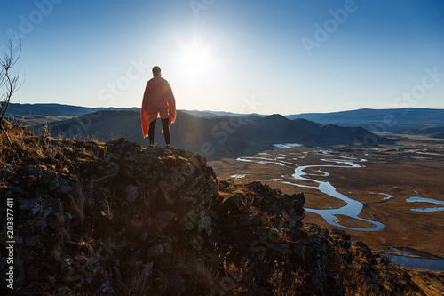 A girl standing in hills at sunset