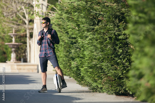  A young man on a monocycle stopped outside and enjoyed a beautiful view of nature. © Denys