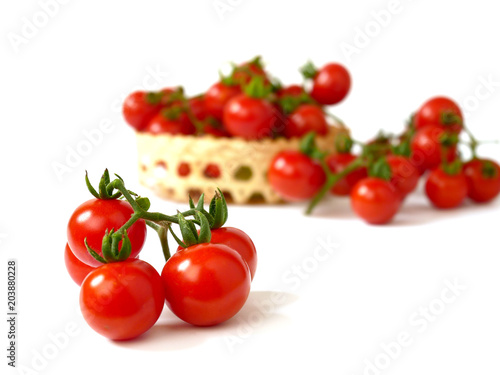 Tomatos in basket isolated on white background.