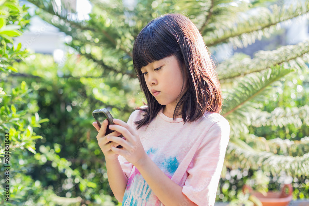 Asian kid girl using smartphone device play game. Asian kid girl using smartphone device play game.