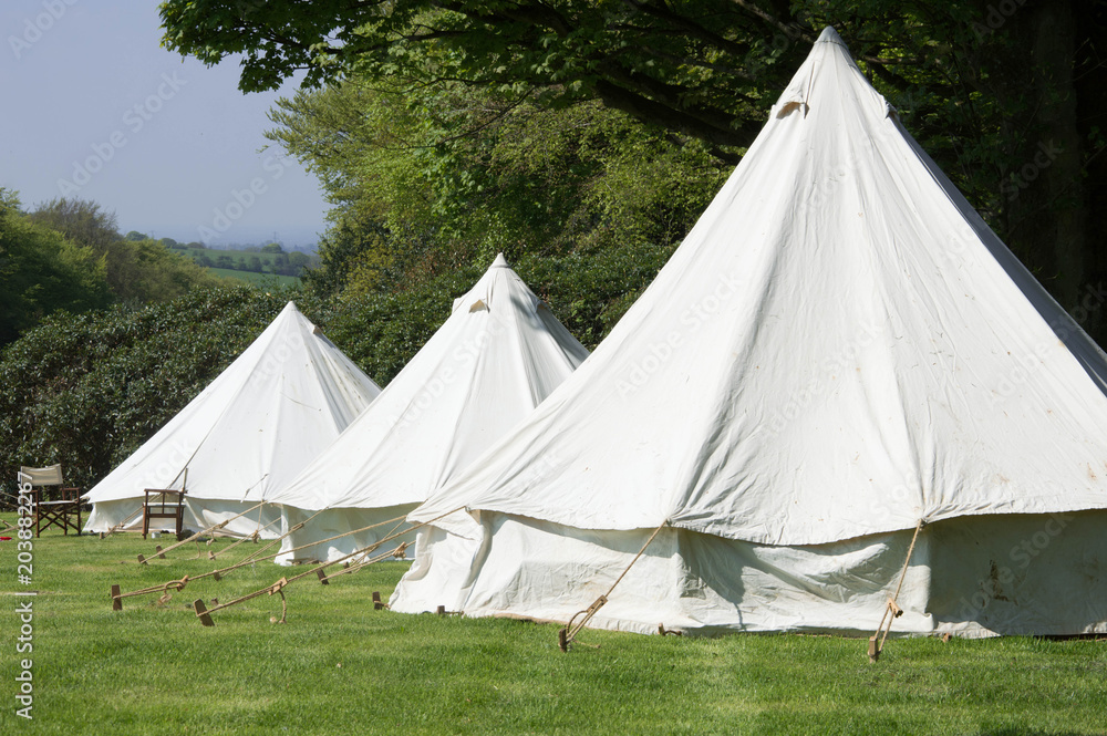 Old style double circular canvas tents in field