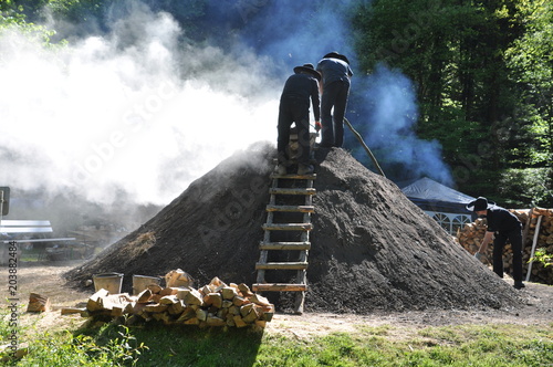 Fotografie Köhler arbeitet am traditionellen Holzkohlemeiler zu Herstellung von Holzkohle a