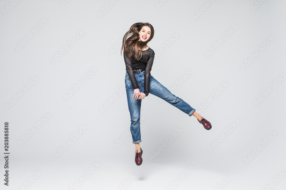 happiness, freedom, power, motion and people concept - smiling young woman jumping in air with raised fists over white background