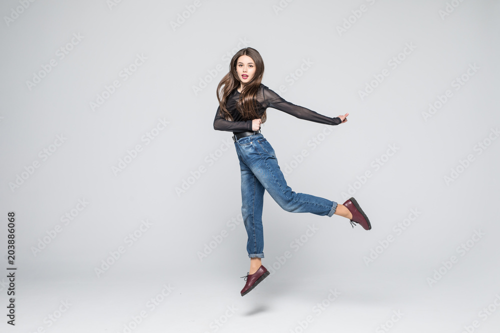 Full length portrait of a cheerful cute woman jumping isolated on white background