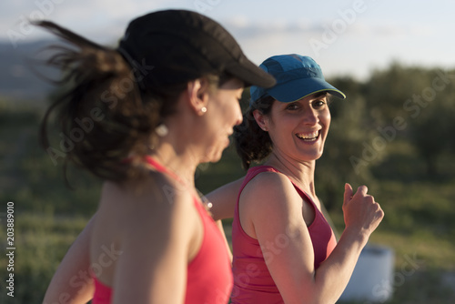  Friends woman talking and smiling outdoors run training in spring day