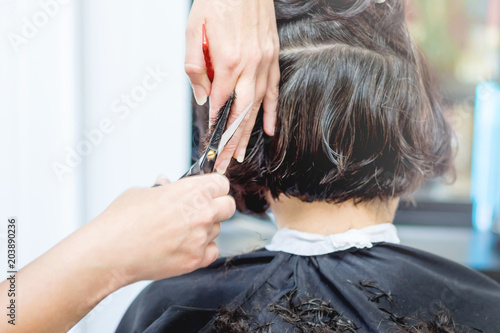 An elderly woman in hairdressing salon. The wizard makes hairstyle for woman_