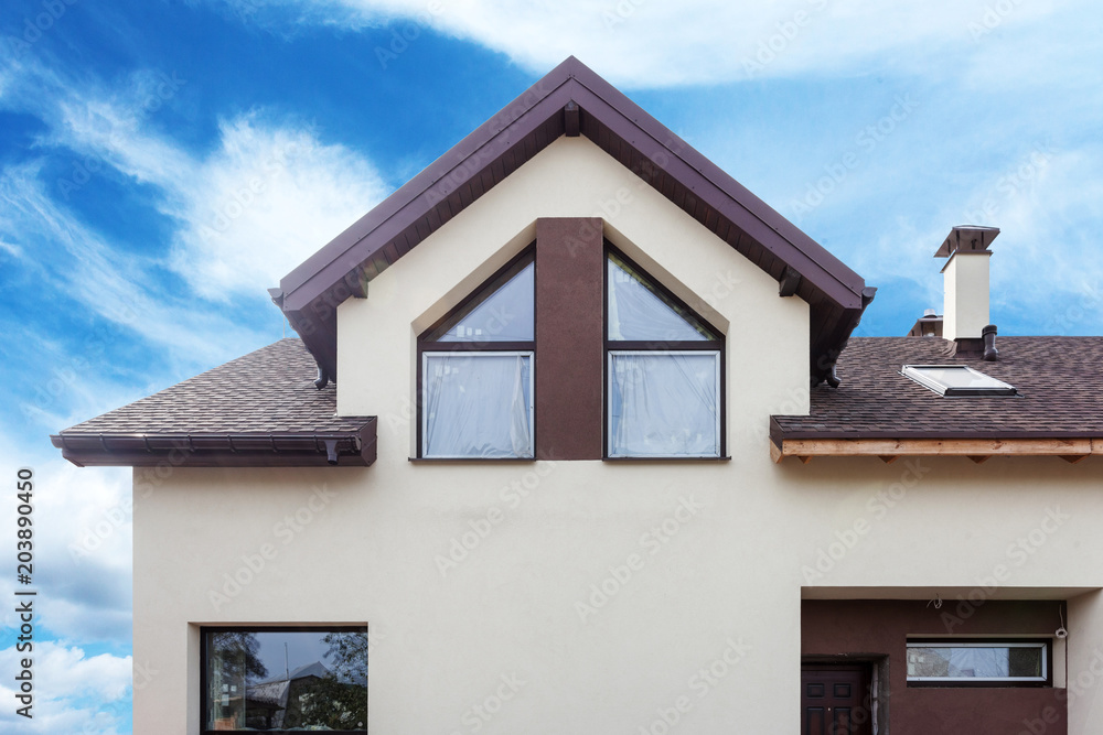 Facade of modern house with metal tile, skylights and plastic or pvc windows Facade of modern house with metal tile, skylights and plastic or pvc windows