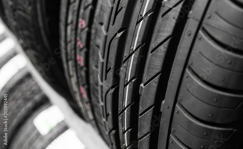 Protector of automobile tires. A number of automobile tires. Close up view on auto mobile new wheel tire surface. Different pattern and type tires for car industry commercial transport transpotration. photo