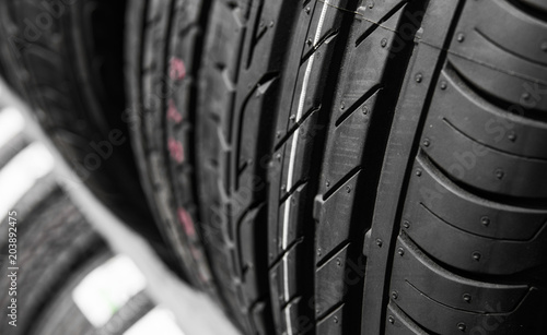 Protector of automobile tires. A number of automobile tires. Close up view on auto mobile new wheel tire surface. Different pattern and type tires for car industry commercial transport transpotration. photo