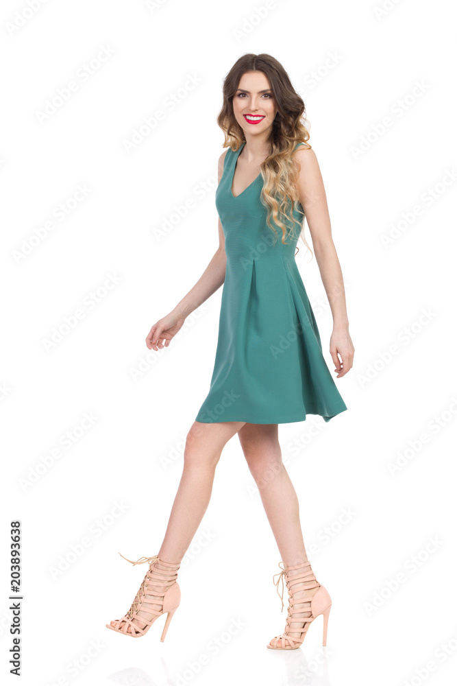 Beautiful Young Woman In Green Mini Dress And High Heels Is Walking And Smiling Beautiful Young Woman In Green Mini Dress And High Heels Is Walking And Smiling
