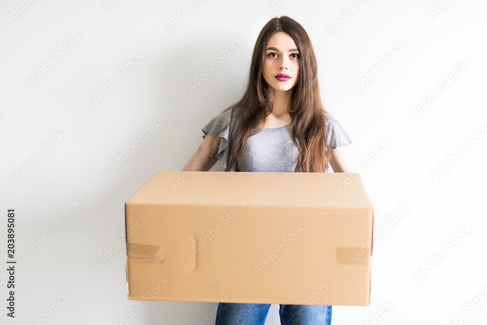 Young woman holding cardboard box moving into new home. Young woman holding cardboard box moving into new home.