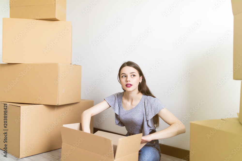 Woman packing and unpacking carton box when moving home. Relocation Woman packing and unpacking carton box when moving home. Relocation