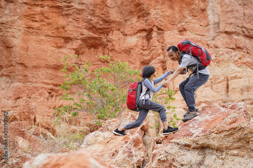 Father and daughter hiking climbing in mountains together success idea concept 3