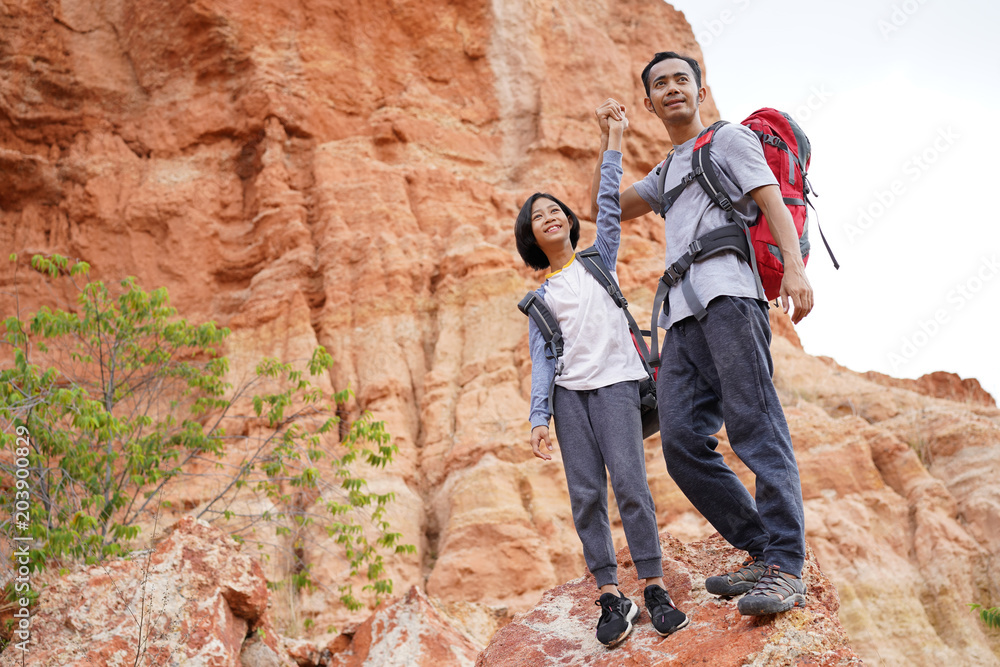 Father and daughter hiking climbing in mountains together success idea concept             3