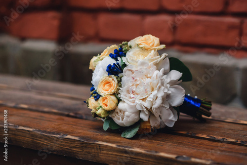 wedding bouquet with yellow roses and white peonies lies