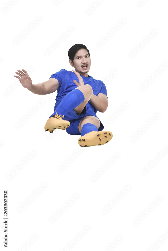 Fototapeta premium Images of asian male soccer player doing sliding tackle