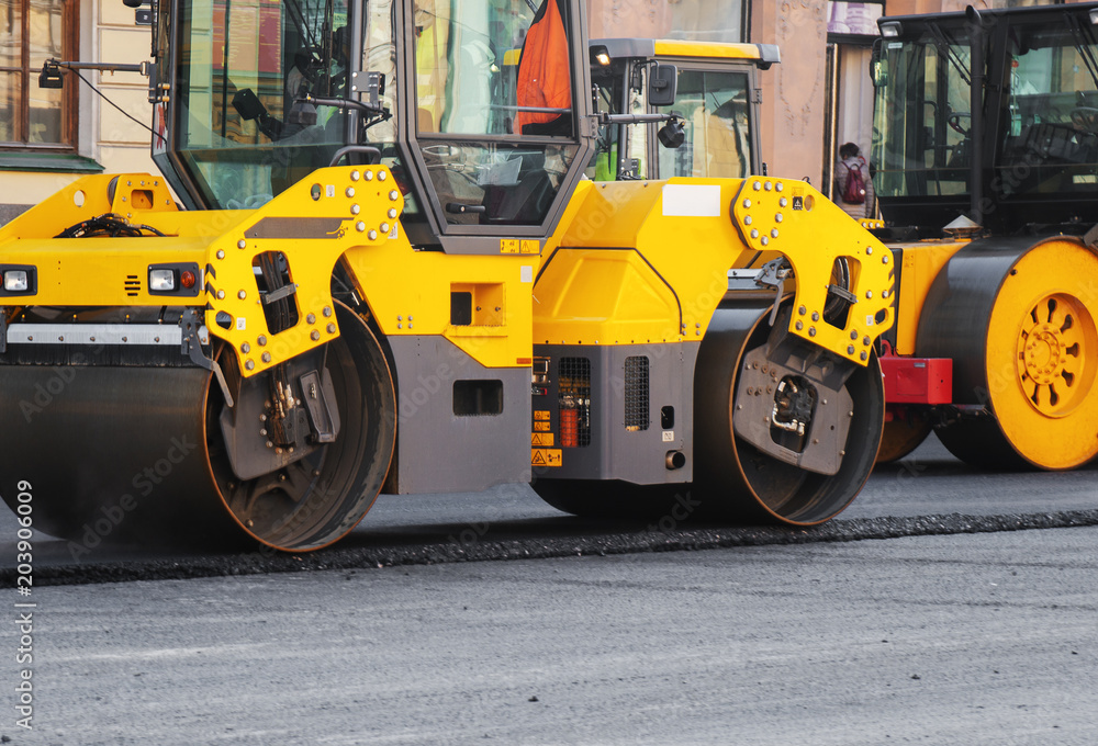 Road re-construction. Road rollers stacking hot asphalt.