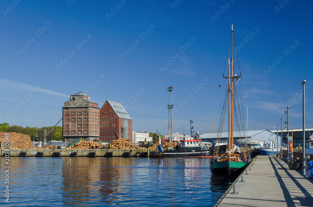 SEA PORT - Old grain warehouses and a sailboat at the wharf

