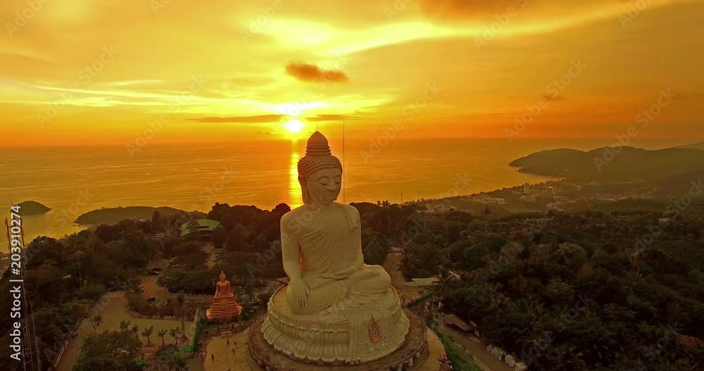 aerial view the white big Buddha statue on the high mountain in sunset time. Phuket big Buddha on hilltop can see around Phuket island behind Phuket big Buddha is Karon gulf in front is Chalong gulf. aerial view the white big Buddha statue on the high mountain in sunset time. Phuket big Buddha on hilltop can see around Phuket island behind Phuket big Buddha is Karon gulf in front is Chalong gulf.