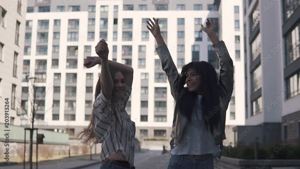 two crazy girls dancing and fooling around outdoors. slow motion two crazy girls dancing and fooling around outdoors. slow motion