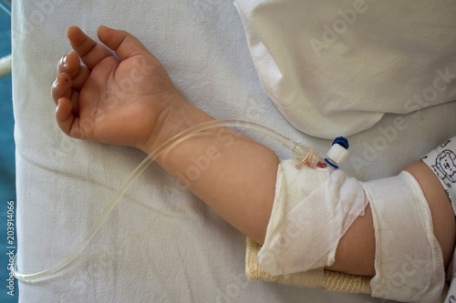 Child in hospital bed with saline intravenous.Little patient