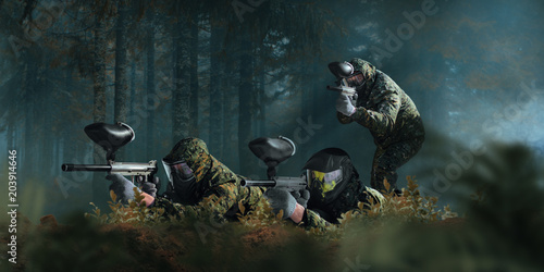 Paintball team shooting in forest battle photo