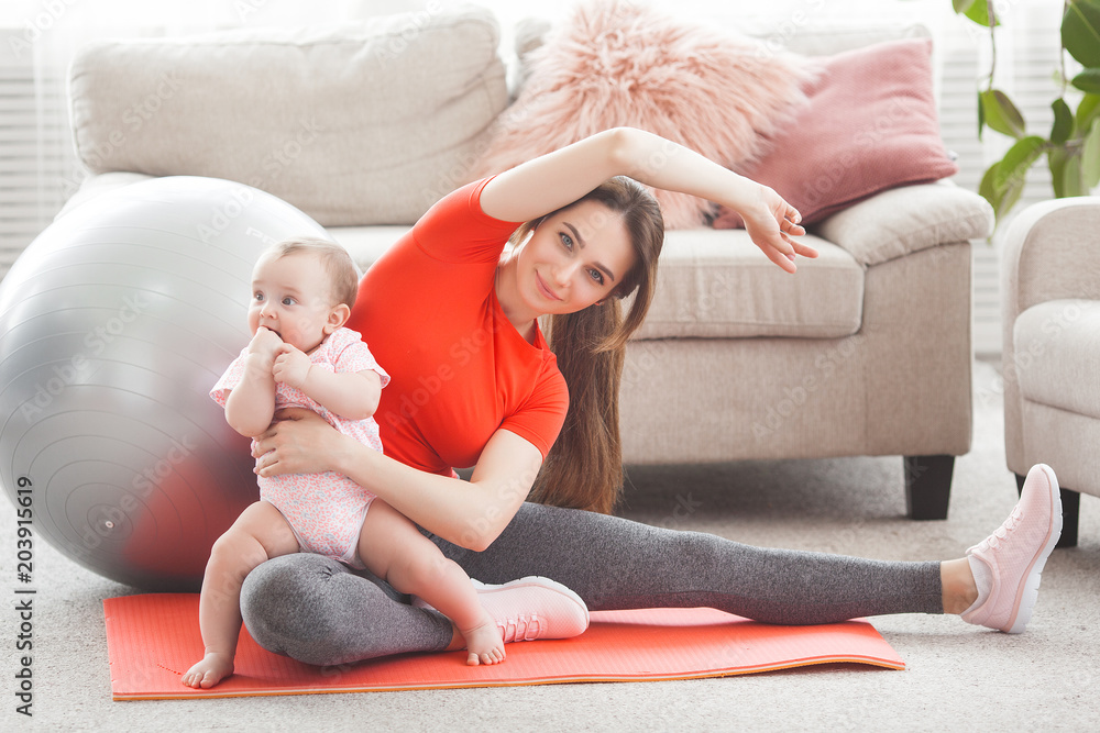 Young pretty mother working out with her little child at home Young pretty mother working out with her little child at home