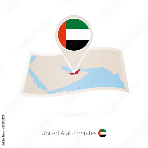 Folded paper map of United Arab Emirates with flag pin of UAE.