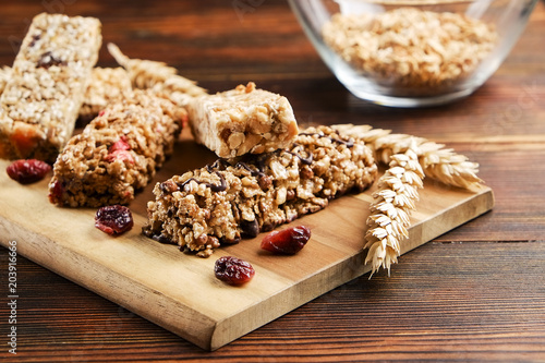 Bunch of mixed gluten free granola energy bars with dried fruit & various nuts, wooden background. Healthy vegan super food, different fitness diet snacks for sporty lifestyle. Top view, copy space. photo