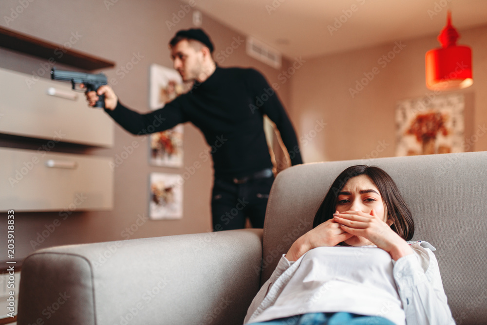 Obraz premium Woman hiding against killer with gun