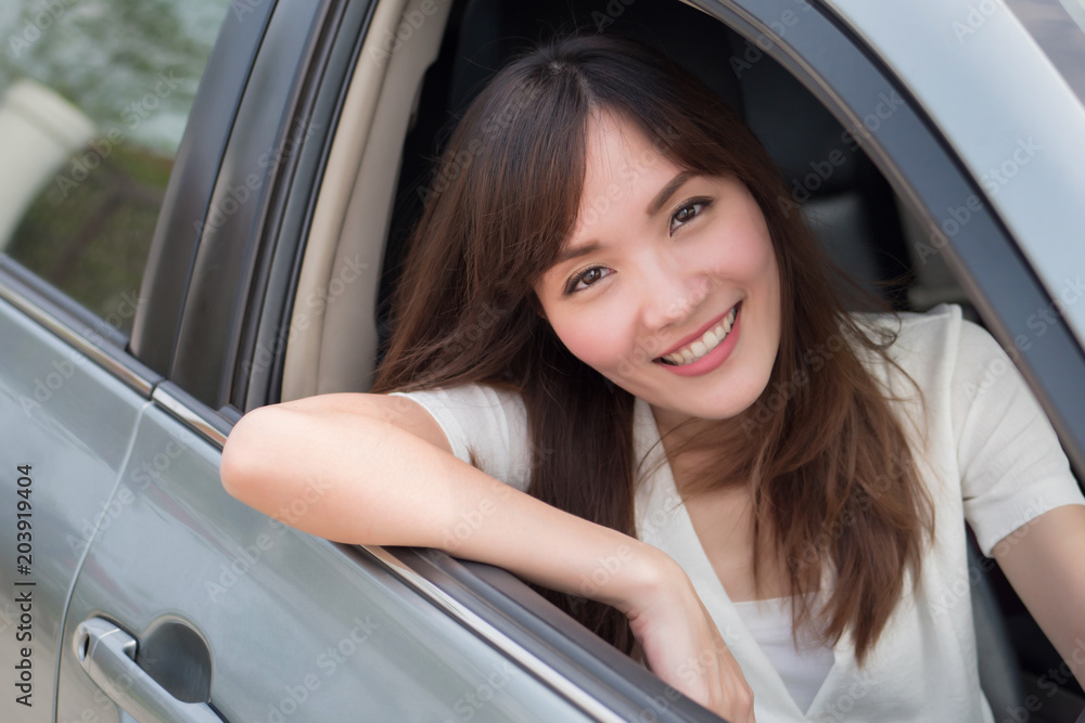 happy woman driving personal car; portrait of happy, smiling, joyful asian woman driving her car, left hand driving or left hand traffic style; 30s adult asian Chinese woman model