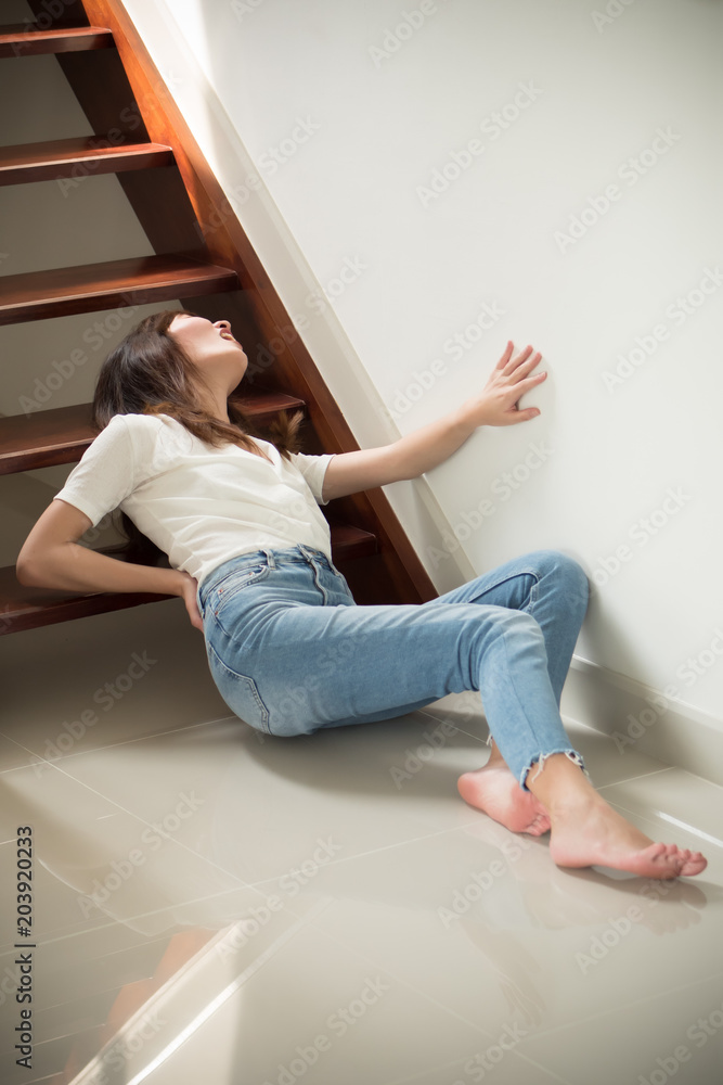 injured woman with hip pain or back injury; portrait of asian woman falling  from stair, having