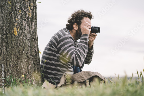 Man photojournalist poses with his photo camera photo