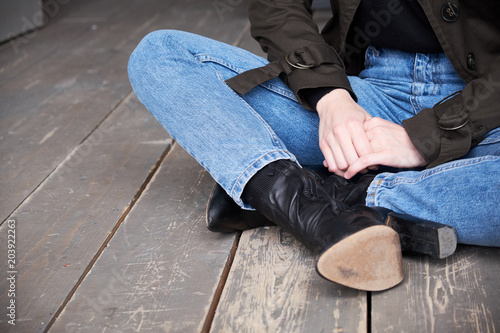 Closeup of female wearing jeans. Trendy hipster outfit style. woman sitting on the floor
