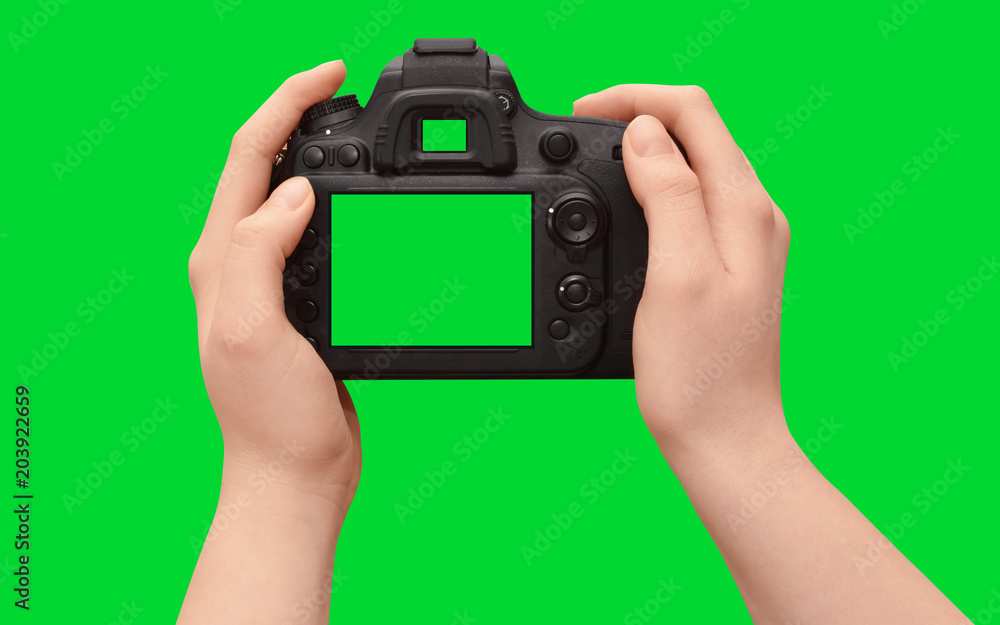 Naklejka premium Hands holding dslr camera with empty screen, isolated on green background