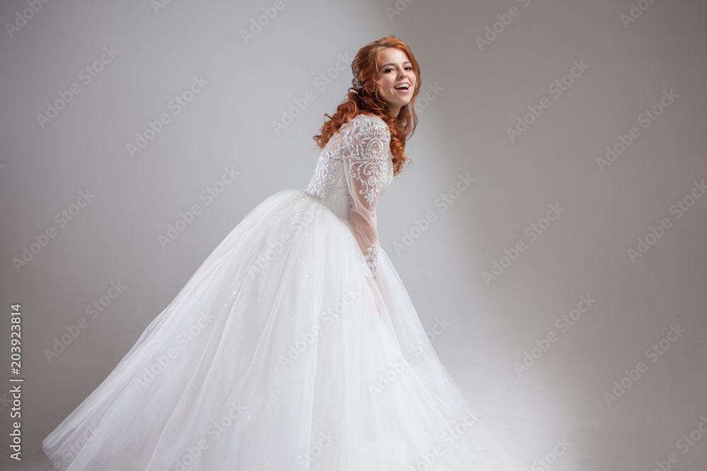 Lovely young woman bride in lavish wedding dress. Light background. Lovely young woman bride in lavish wedding dress. Light background.