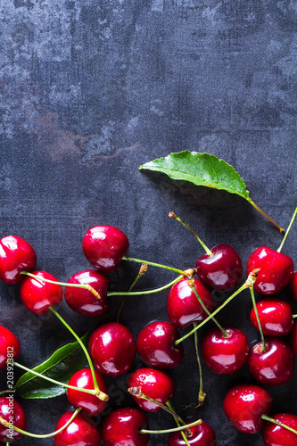 Fresh red ripe cherries on dark grey table