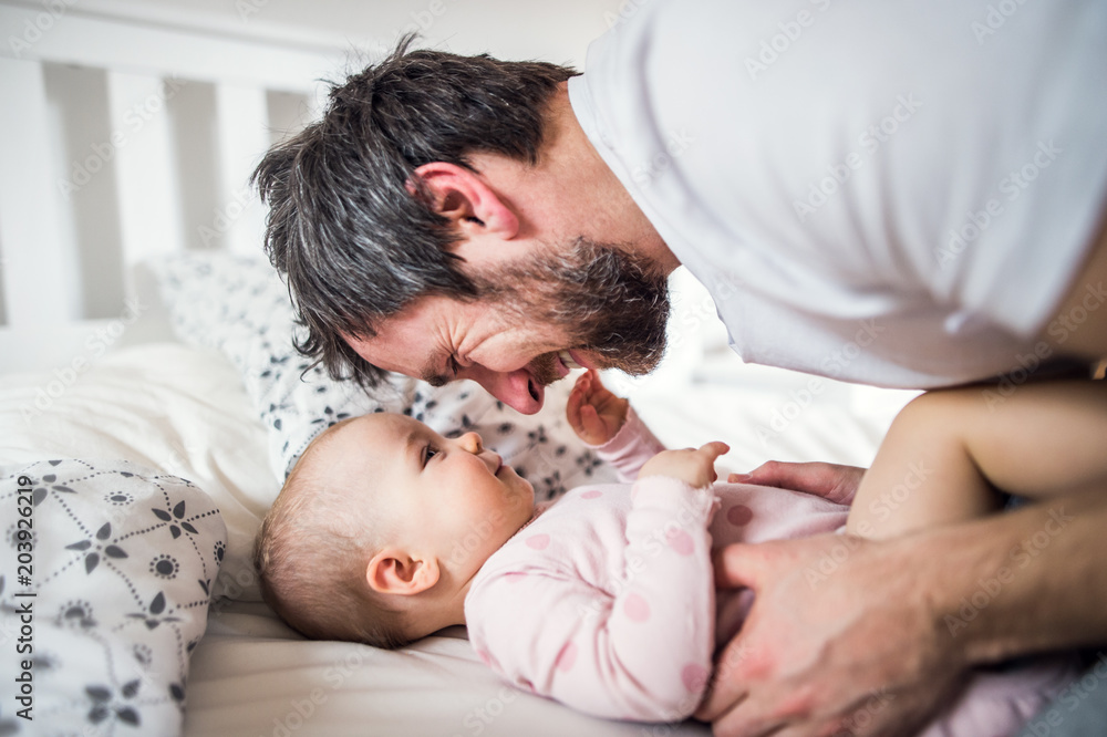 Father with a toddler girl on bed at home at bedtime. Father with a toddler girl on bed at home at bedtime.