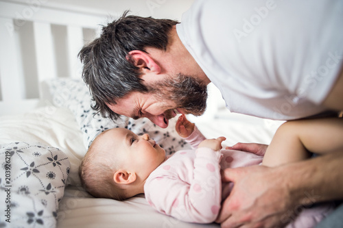 Father with a toddler girl on bed at home at bedtime.