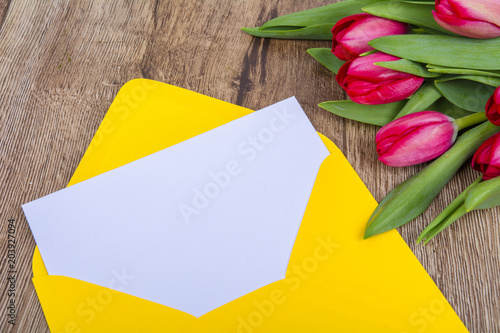 Yellow envelope with tulips on a table