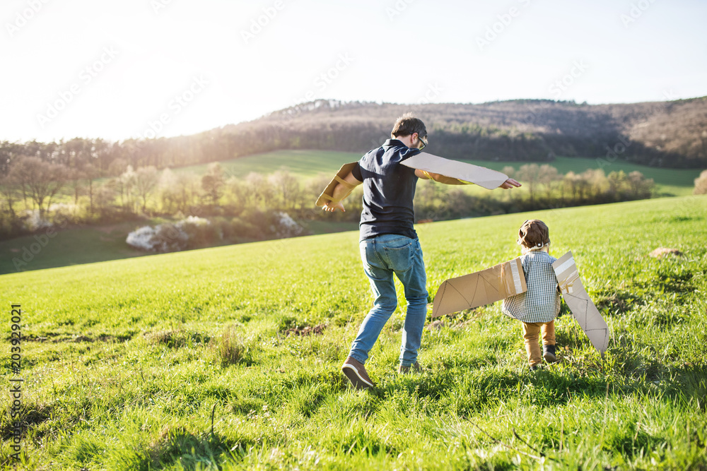 Happy toddler boy playing outside with father in spring nature. Happy toddler boy playing outside with father in spring nature.