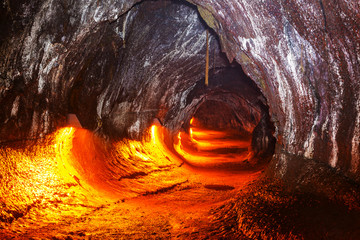 Fotobehang Vulkaan Lavatunnel met gloeiende lavastroom  © Galyna Andrushko
